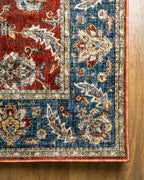 Red traditional rug with ornate floral patterns and blue border design