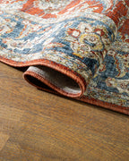 Red traditional rug with ornate floral patterns and blue border design