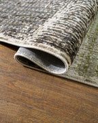 Modern geometric patchwork rug in green, black, and neutral tones with textured weave