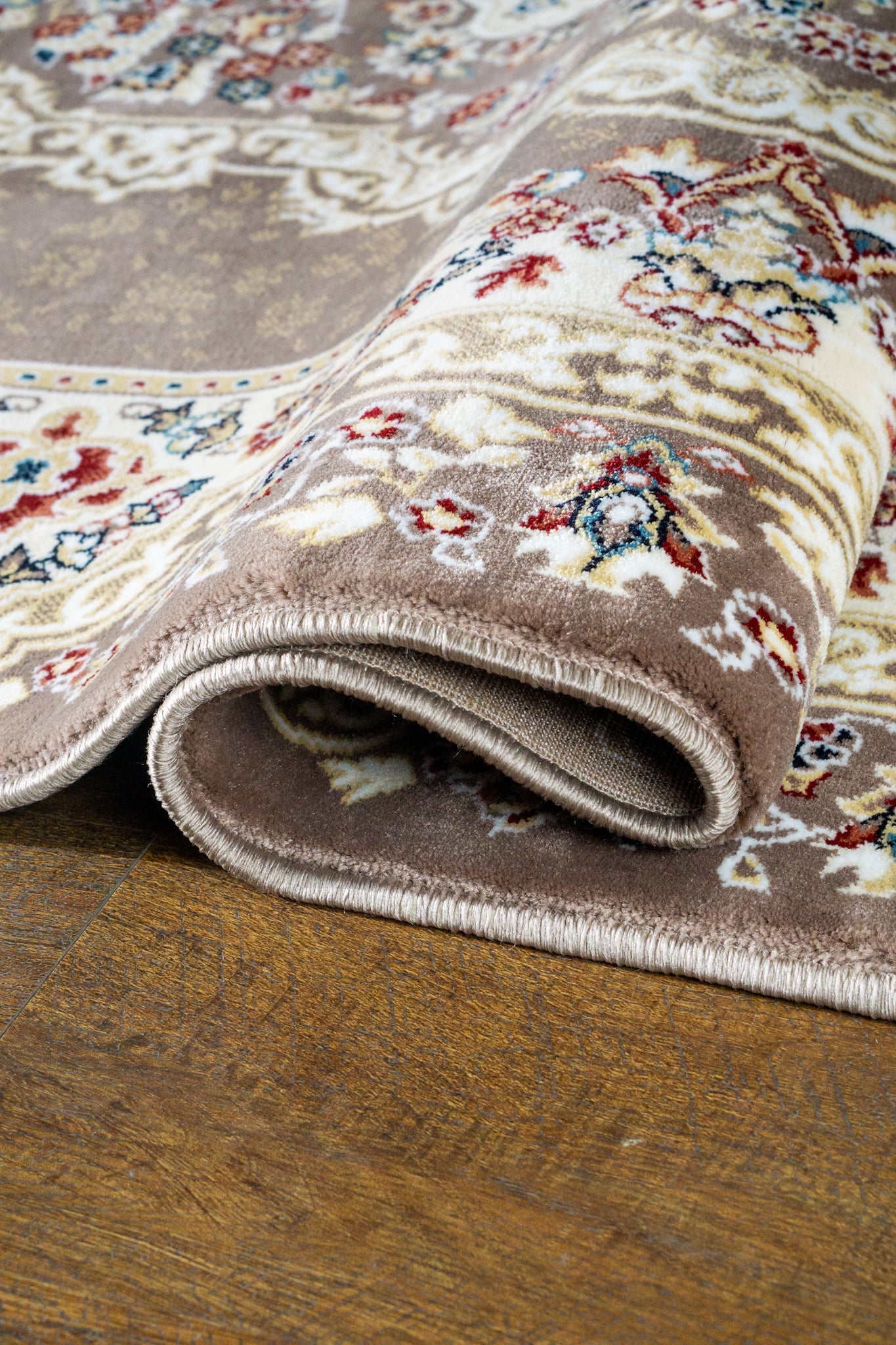 Brown traditional Persian rug with cream medallion and ornate floral borders