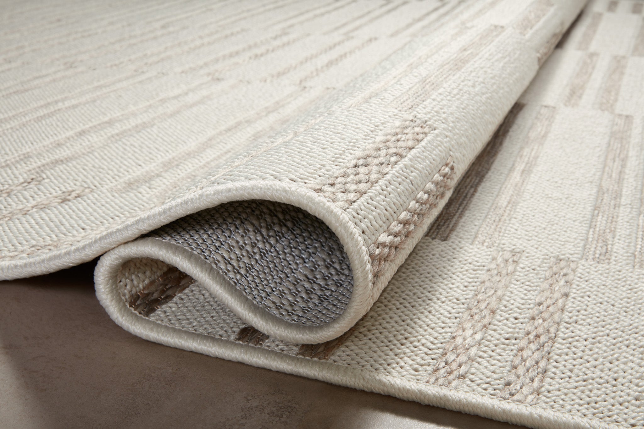 Beige and taupe striped area rug with geometric block pattern design