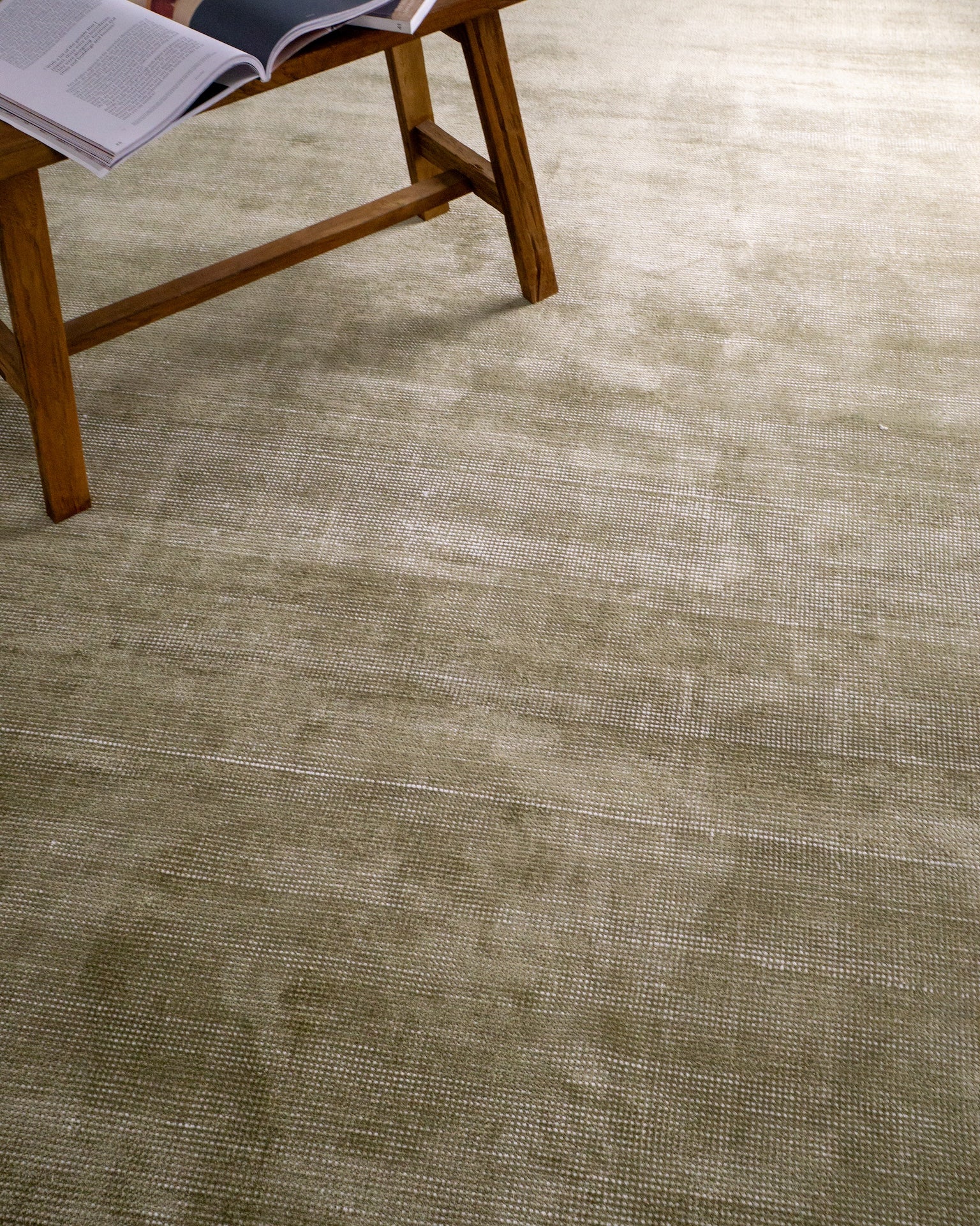 Sage green velvet rug with subtle texture and solid mottled pattern