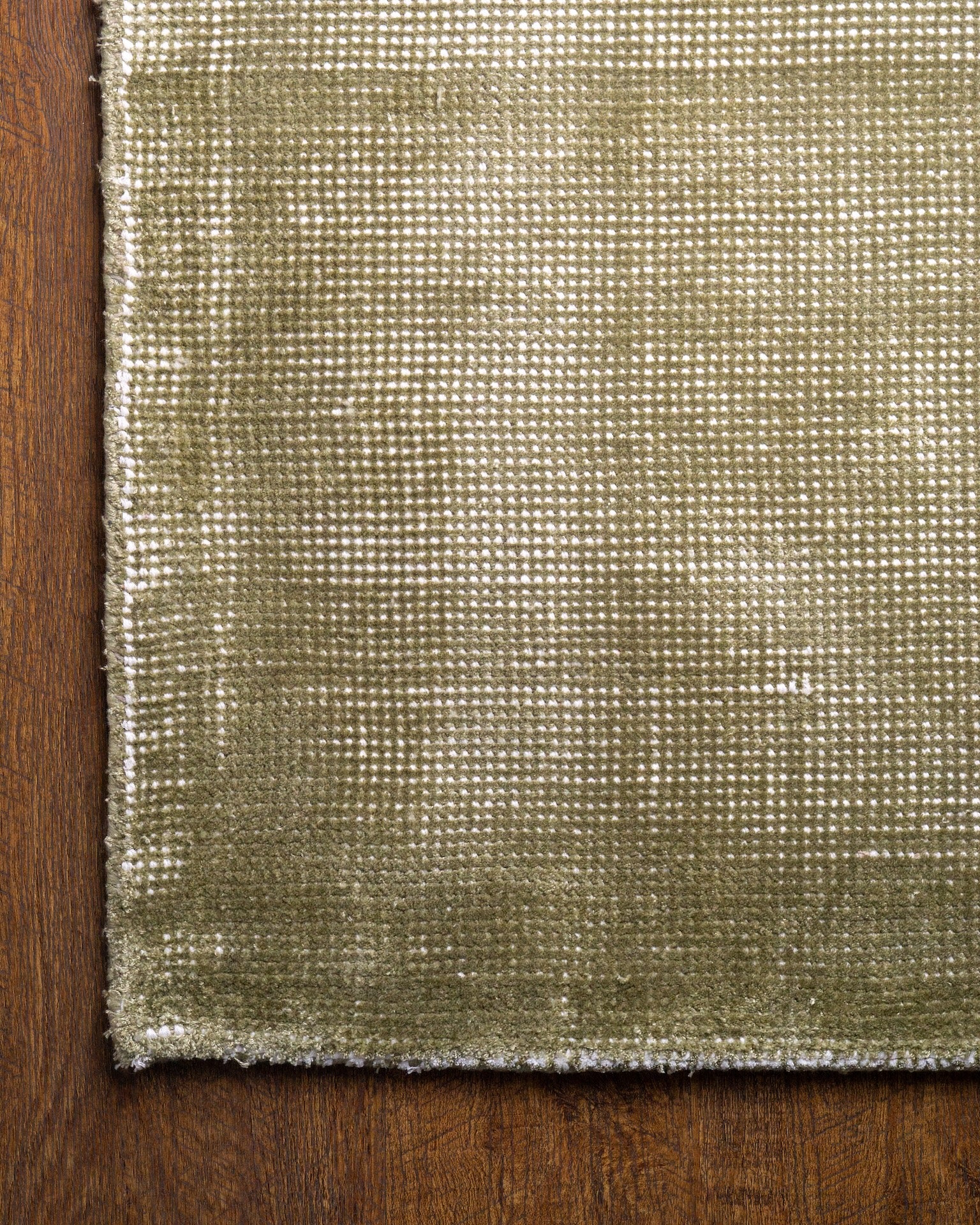 Sage green velvet rug with subtle texture and solid mottled pattern