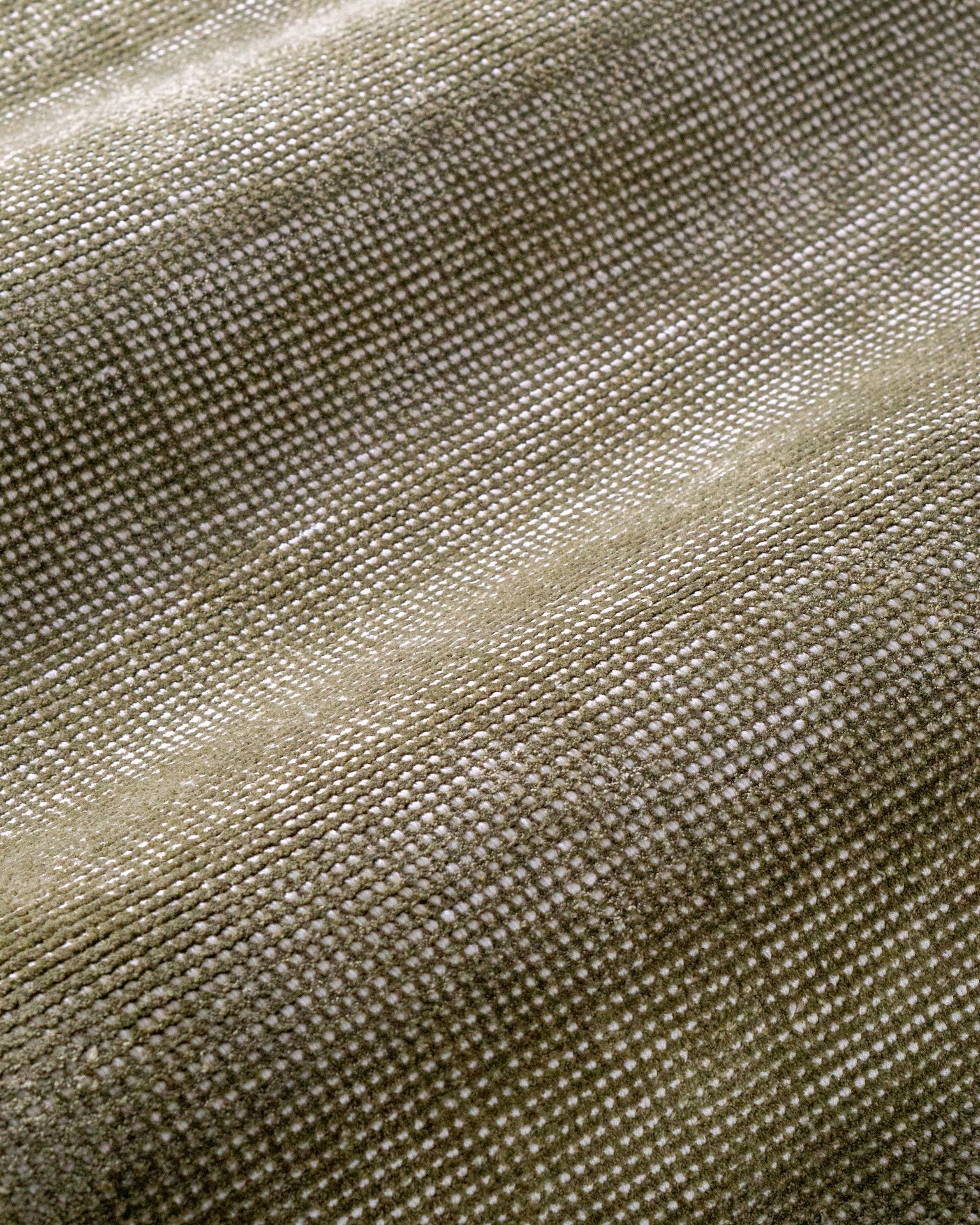 Sage green velvet rug with subtle texture and solid mottled pattern