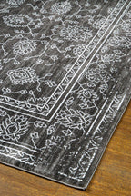 Charcoal grey distressed rug with intricate ivory floral medallion pattern and borders