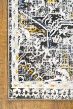 Vintage-style rug with ornate geometric patterns in gray, gold, and black tones