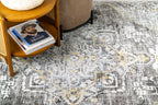 Vintage-style rug with ornate geometric patterns in gray, gold, and black tones