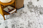 Distressed grey and white rug with abstract speckled texture and worn finish