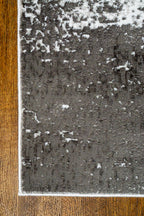 Distressed grey and white rug with abstract speckled texture and worn finish