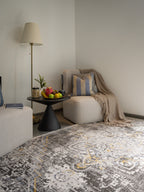 Vintage-style rug with ornate geometric patterns in gray, gold, and black tones