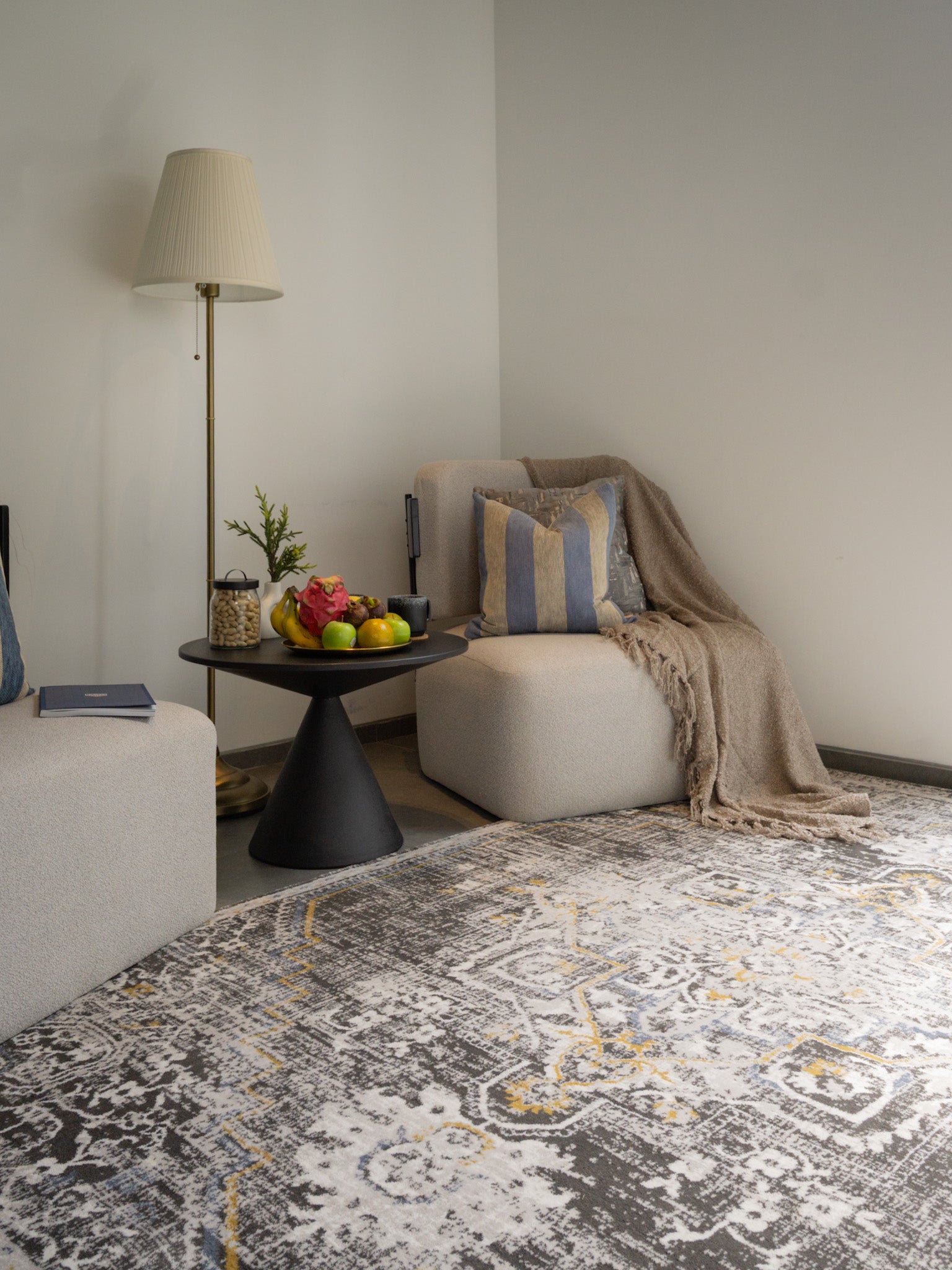 Vintage-style rug with ornate geometric patterns in gray, gold, and black tones