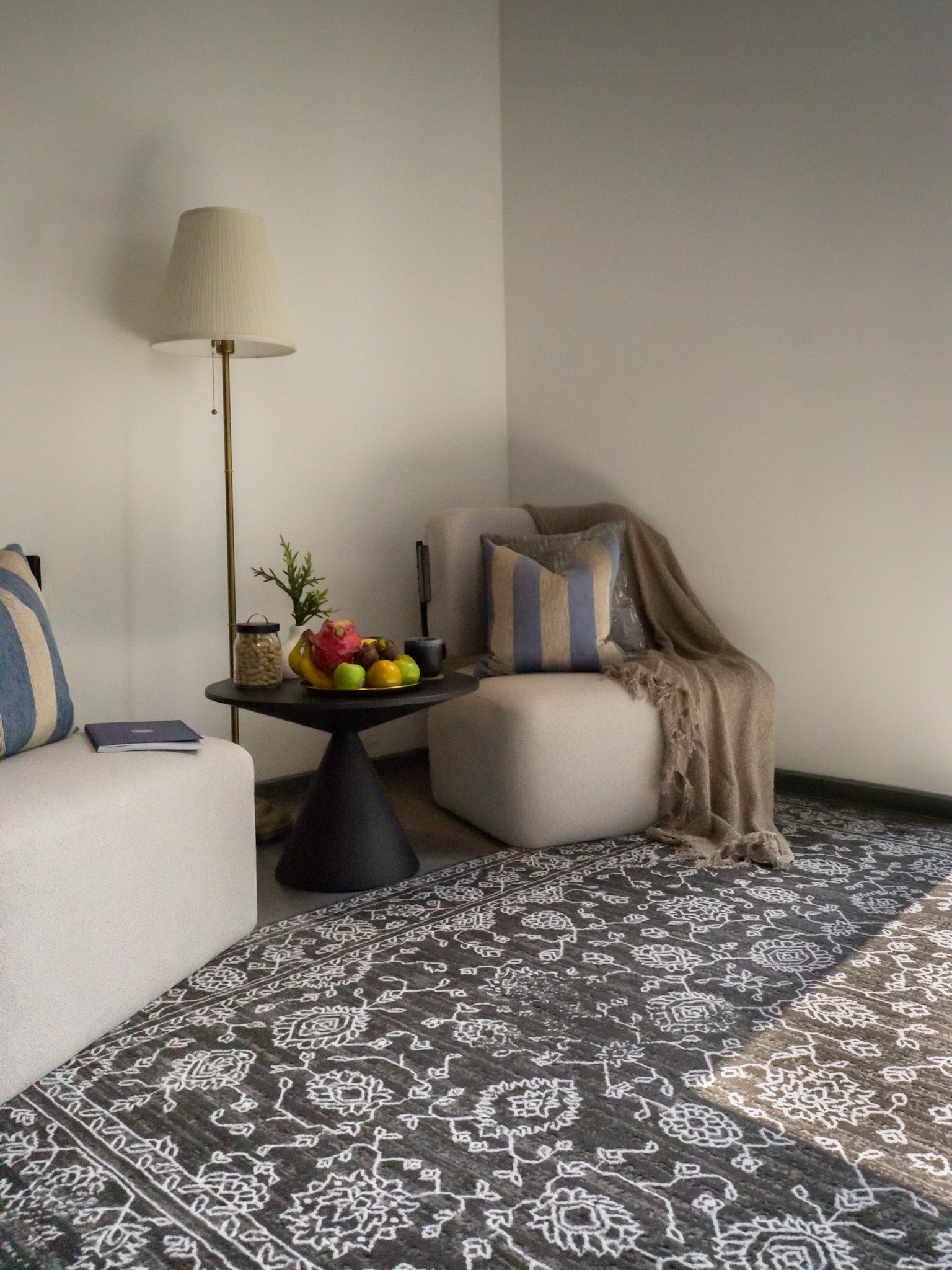 Charcoal grey distressed rug with intricate ivory floral medallion pattern and borders