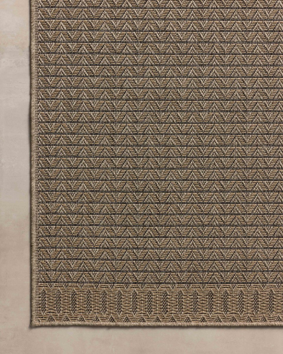 Tan and brown geometric patterned rug with textured weave and striped borders