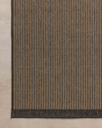 Neutral striped rug with subtle texture and dark border detail