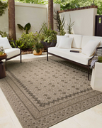 Beige geometric patterned rug with layered borders and textured woven appearance