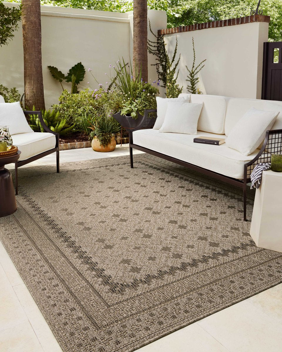Beige geometric patterned rug with layered borders and textured woven appearance