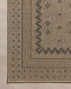 Beige geometric patterned rug with layered borders and textured woven appearance
