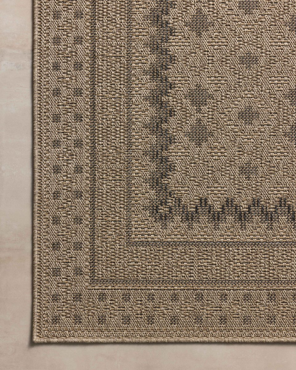 Beige geometric patterned rug with layered borders and textured woven appearance