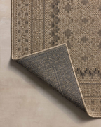 Beige geometric patterned rug with layered borders and textured woven appearance