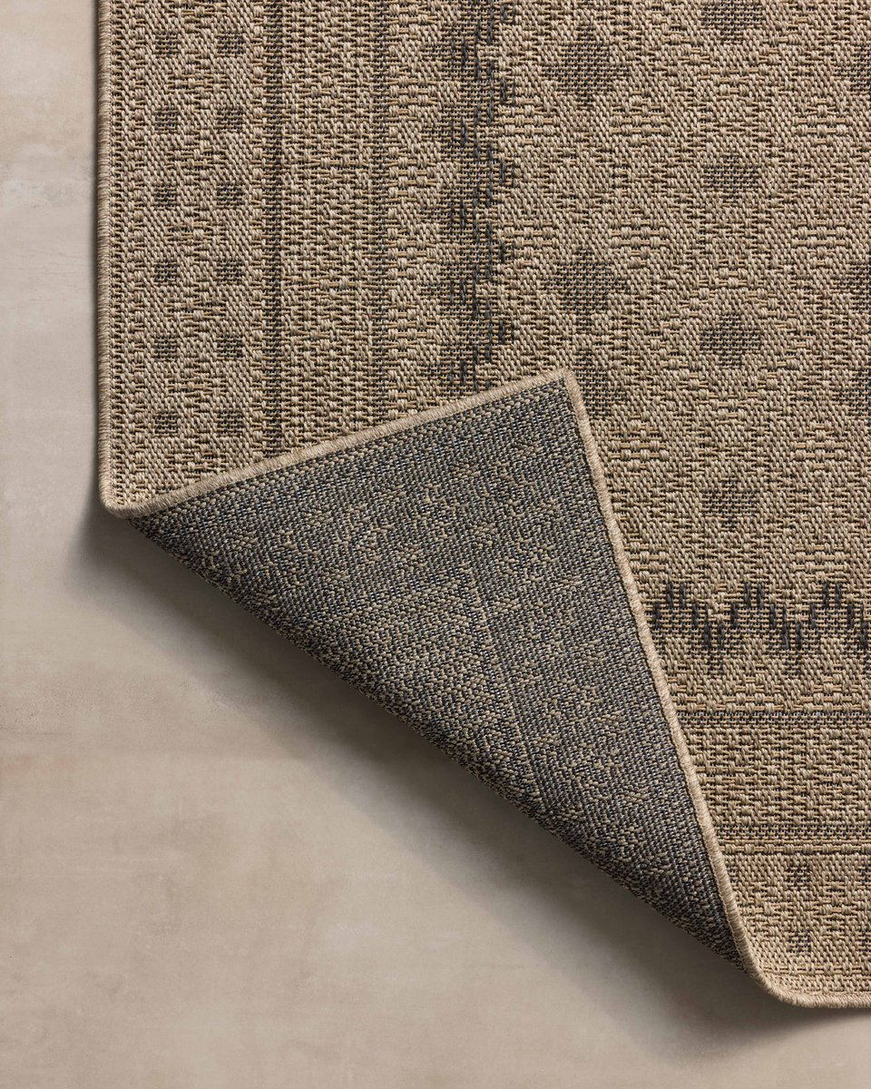 Beige geometric patterned rug with layered borders and textured woven appearance