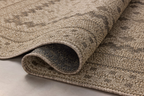 Beige geometric patterned rug with layered borders and textured woven appearance