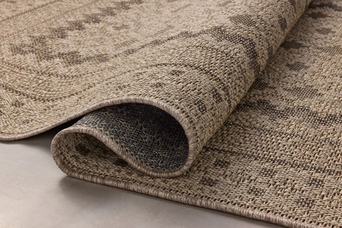 Beige geometric patterned rug with layered borders and textured woven appearance