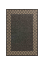 Charcoal grey and tan bordered outdoor rug in modern patio seating area