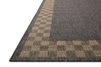 Charcoal grey and tan bordered outdoor rug in modern patio seating area