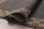 Charcoal grey and tan bordered outdoor rug in modern patio seating area