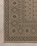 Beige geometric patterned rug with diamond motifs and decorative borders
