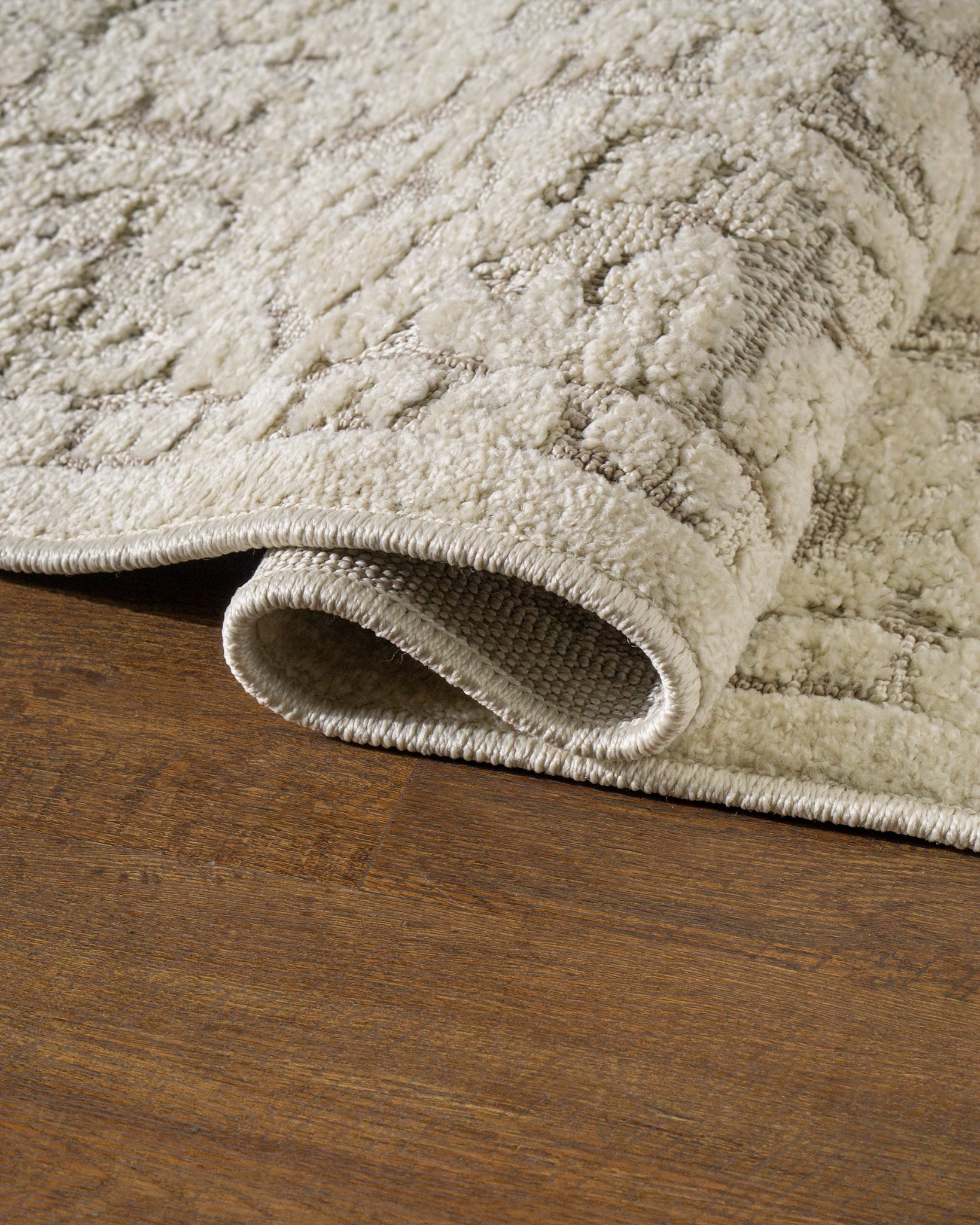 Cream and taupe traditional floral patterned area rug with ornate border