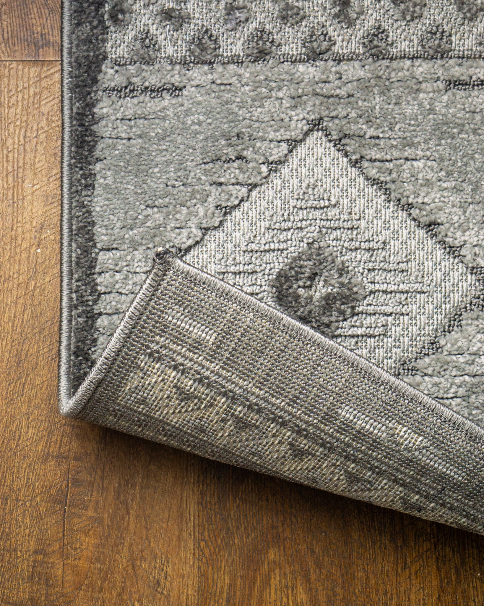 Gray geometric diamond pattern area rug with tribal motifs and striped borders