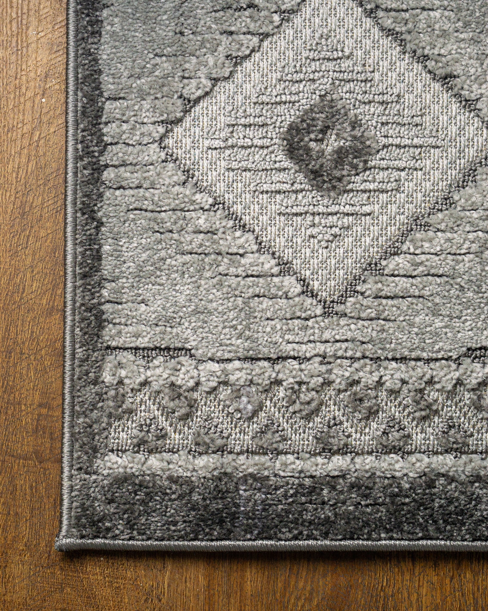 Gray geometric diamond pattern area rug with tribal motifs and striped borders
