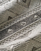 Gray geometric diamond pattern area rug with tribal motifs and striped borders