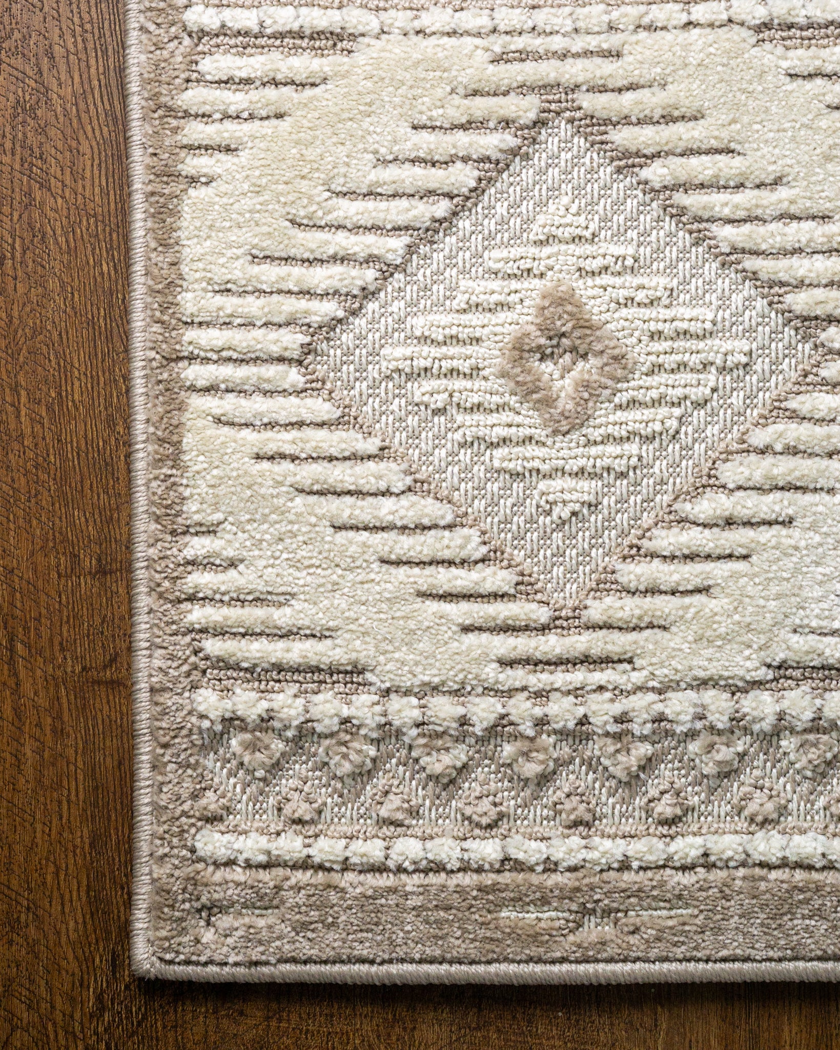 Beige and cream geometric diamond pattern rug with tribal inspired design