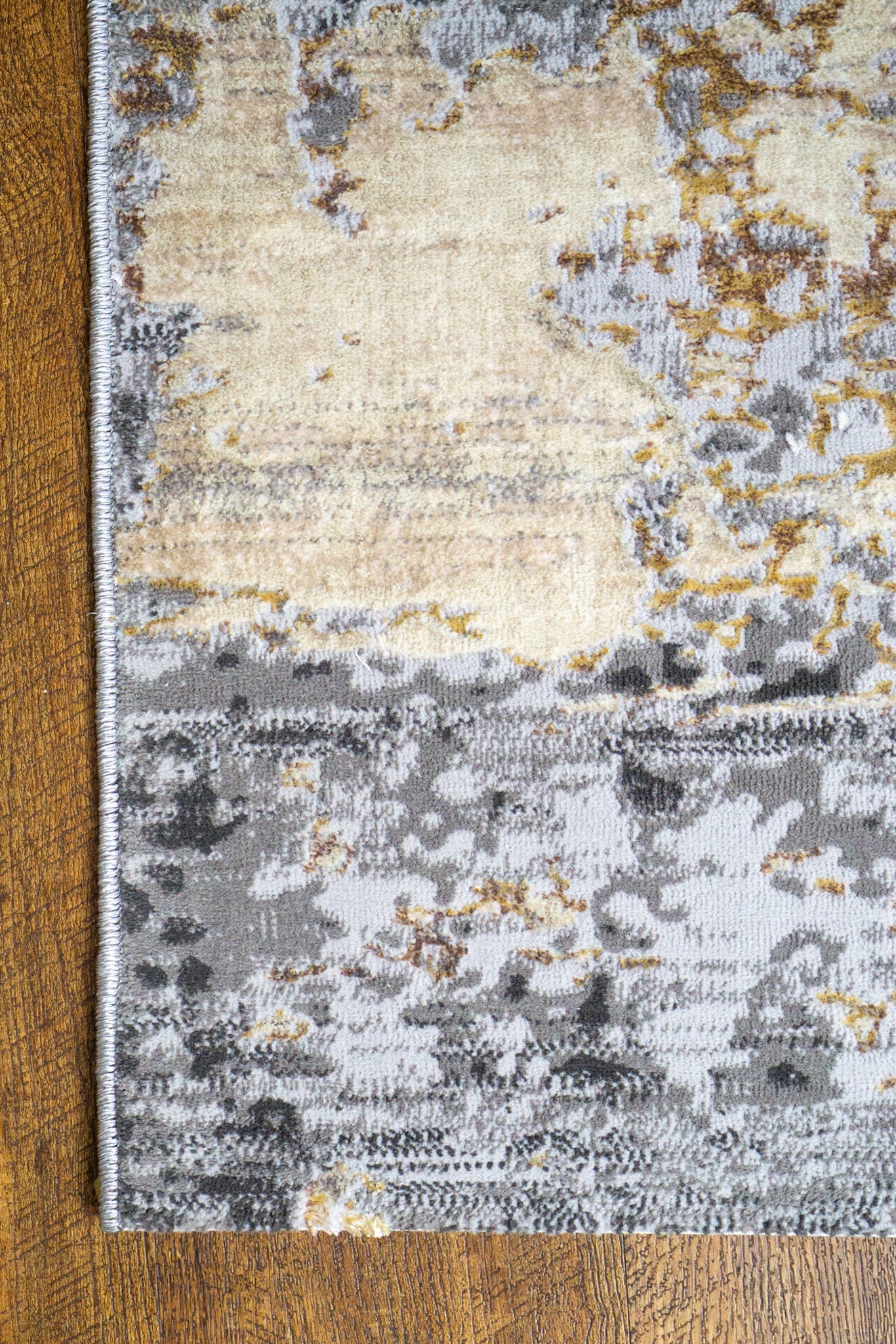 Abstract distressed rug with grey, gold, and cream tones in modern style