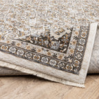 Traditional ornate rug with cream and brown geometric floral border pattern