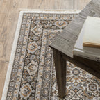 Traditional ornate rug with cream and brown geometric floral border pattern