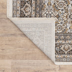 Traditional ornate rug with cream and brown geometric floral border pattern