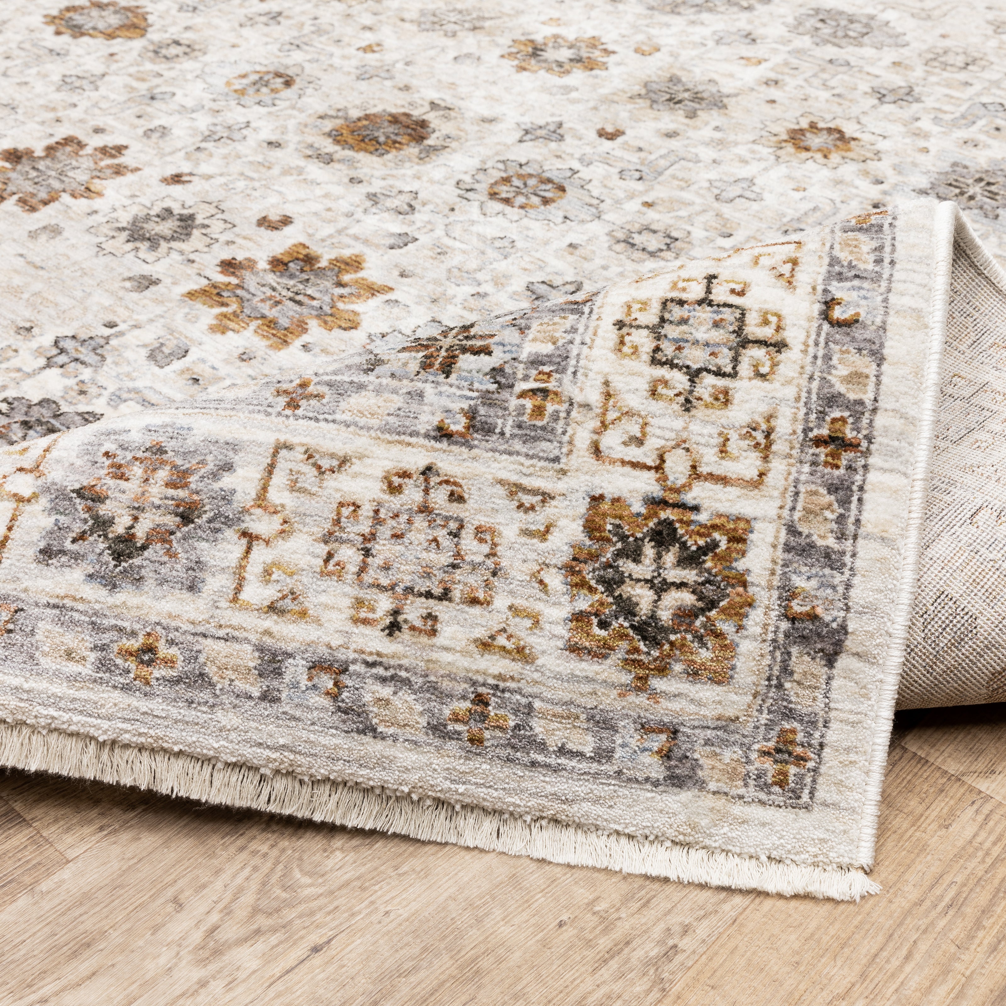 Beige traditional rug with brown and grey floral medallion pattern and ornate border