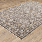 Vintage-style area rug with intricate geometric patterns in beige, taupe and cream tones