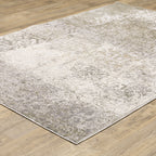 Distressed beige and tan vintage-style area rug with faded ornamental pattern