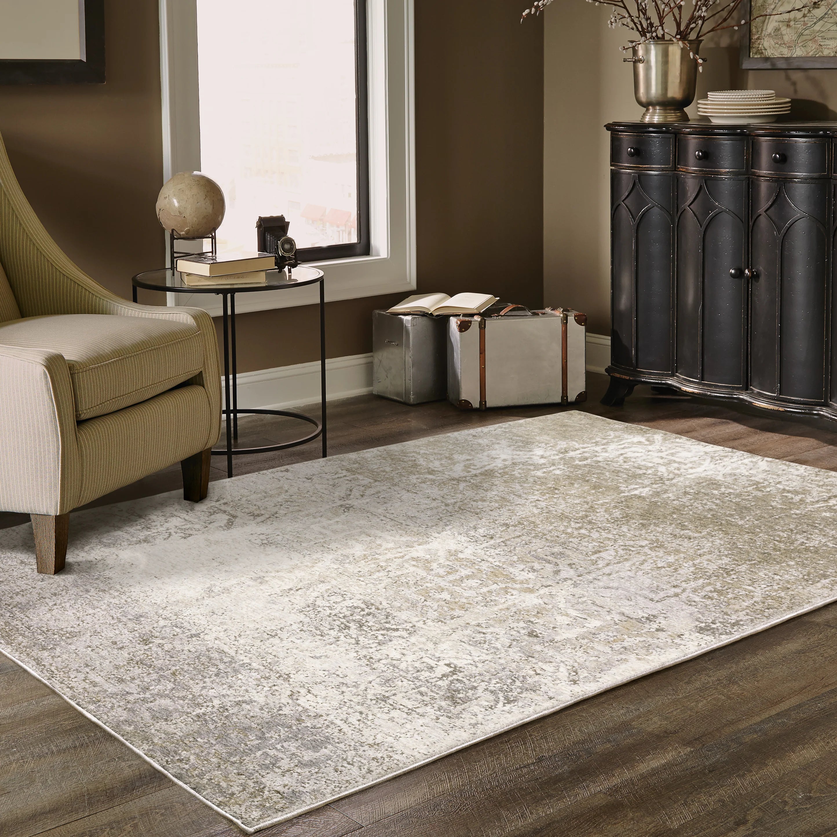 Distressed beige and tan vintage-style area rug with faded ornamental pattern