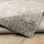 Distressed beige and tan vintage-style area rug with faded ornamental pattern