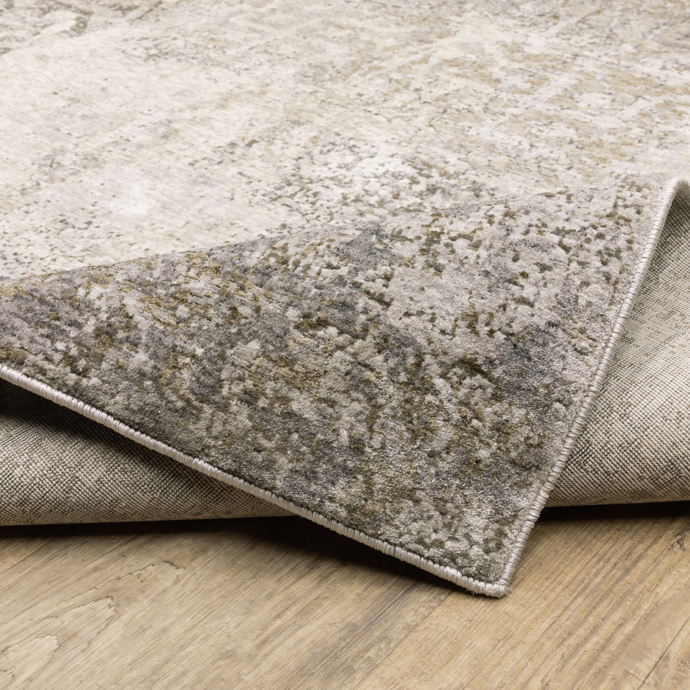 Distressed beige and tan vintage-style area rug with faded ornamental pattern