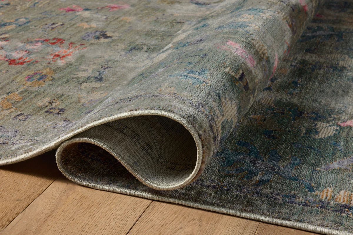 Vintage-style rug with blue-gray base and faded floral pattern in cream and red tones