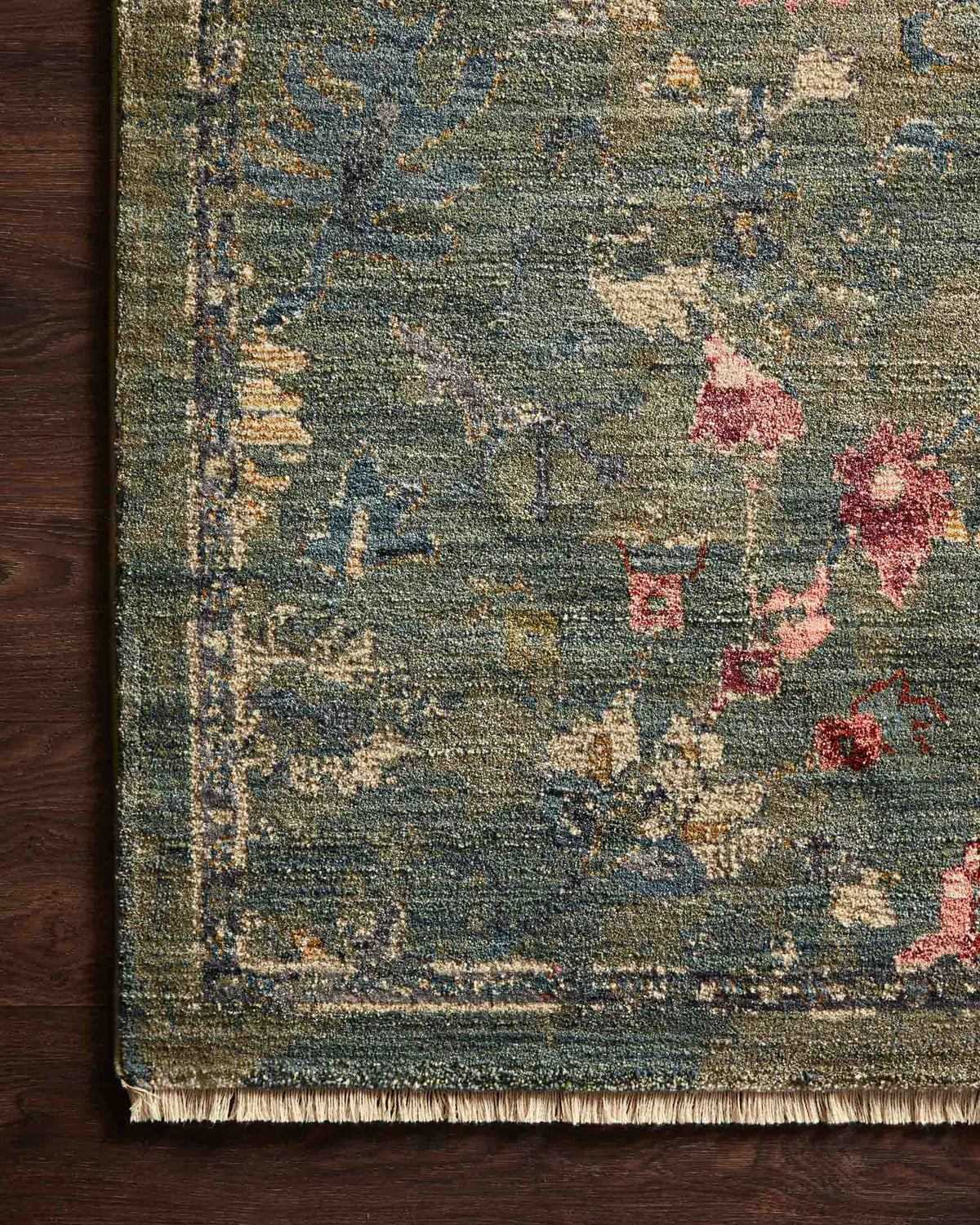 Vintage-style rug with blue-gray base and faded floral pattern in cream and red tones