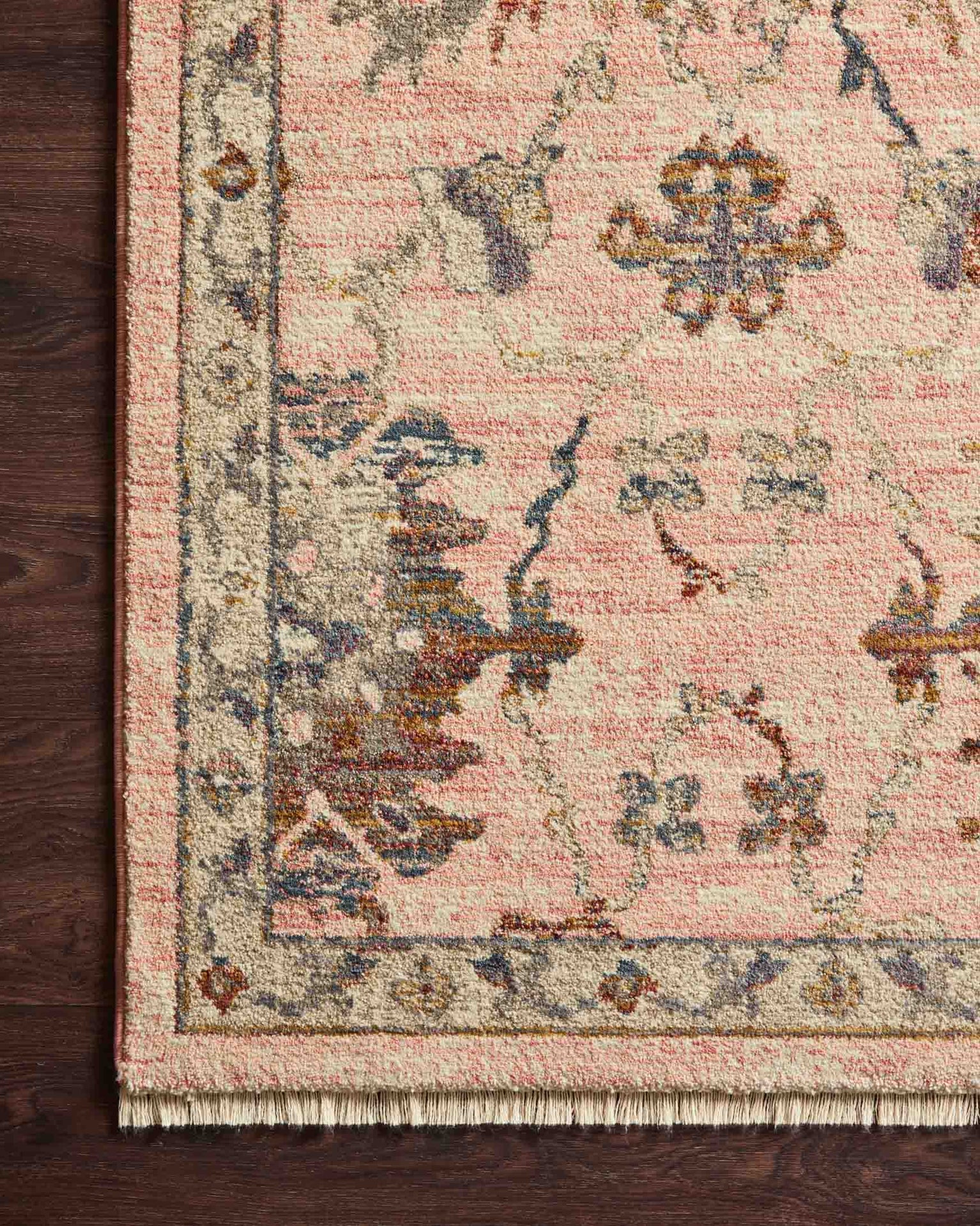 Blush pink traditional rug with intricate floral motifs and ornate border design