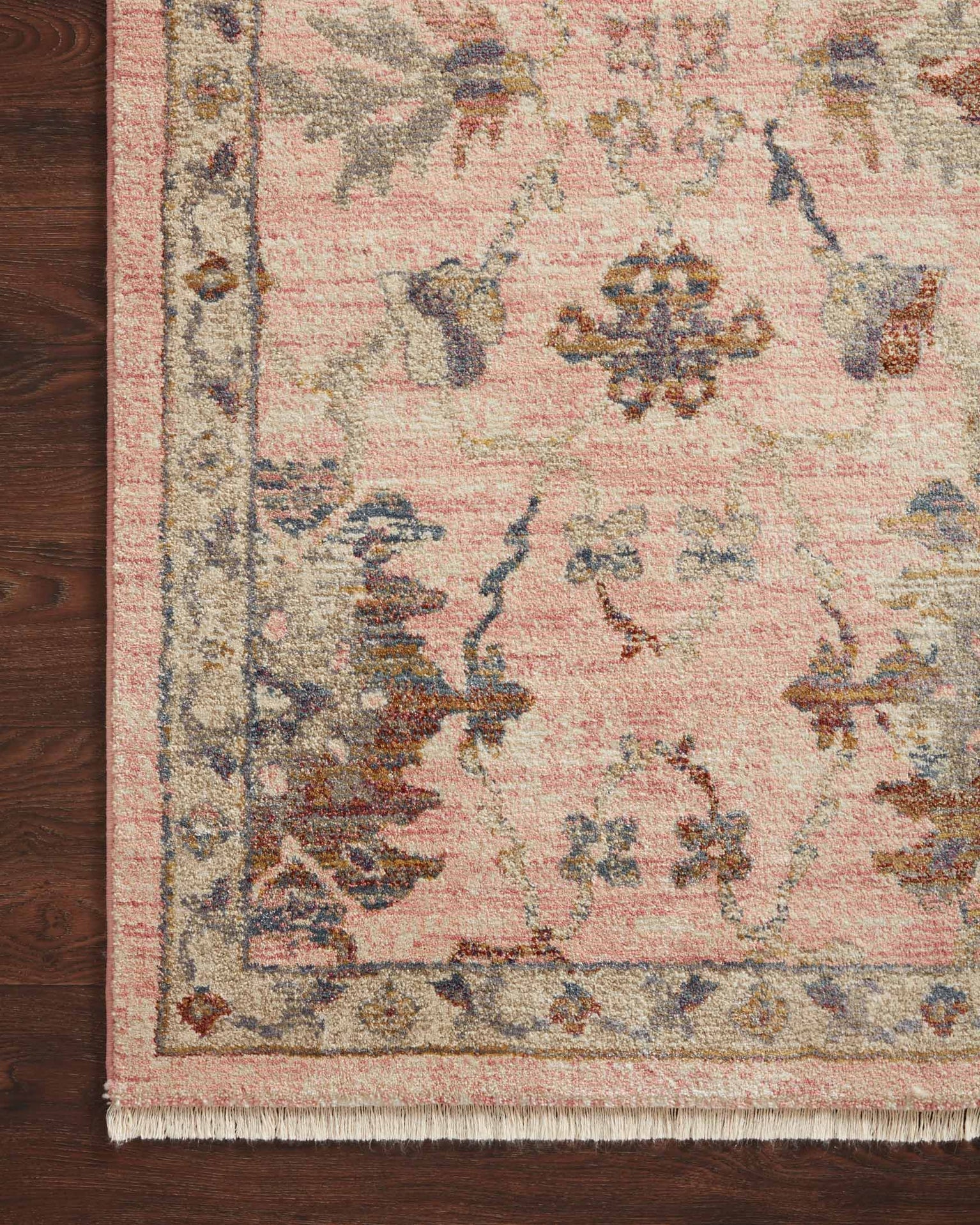 Blush pink traditional rug with intricate floral motifs and ornate border design