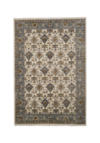Cream and blue traditional rug with geometric diamond patterns and ornate border